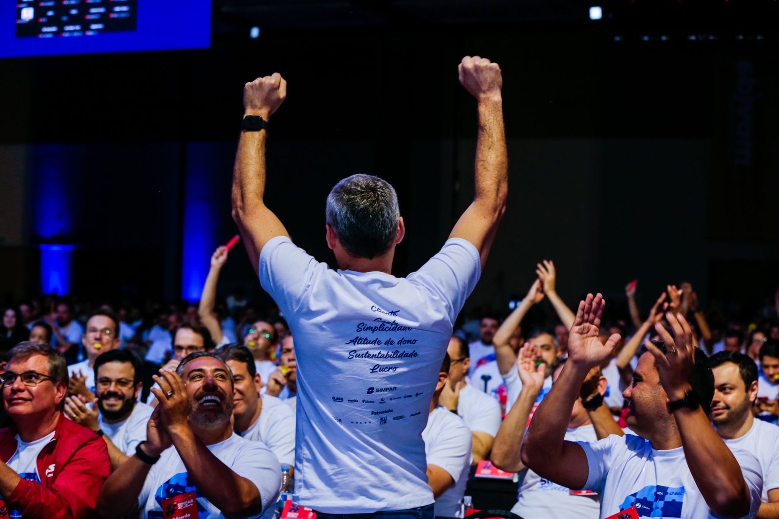excited audience members applauding and cheering for keynote speaker at corporate conference event