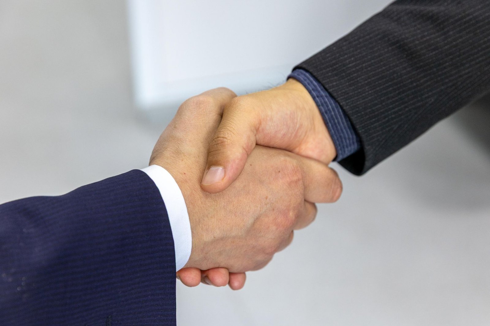 business handshake between professionals representing a keynote speaker booking agreement at a corporate event