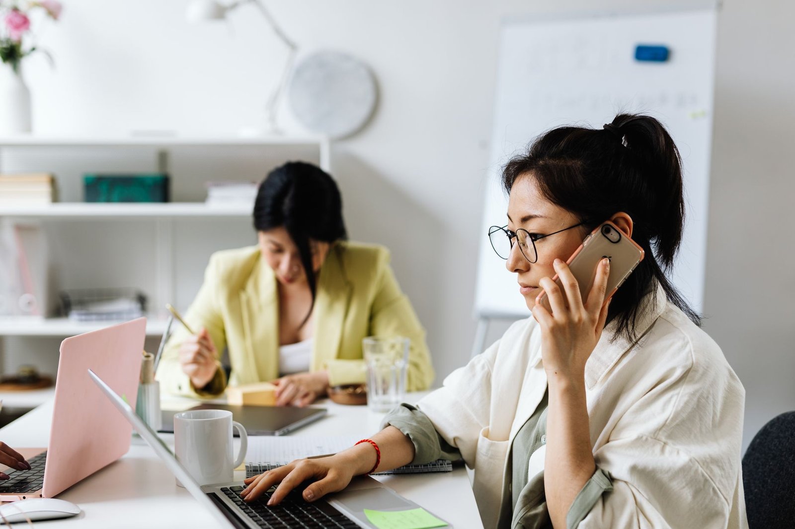 busy event planners multitasking in office comparing multiple keynote speaker websites and options