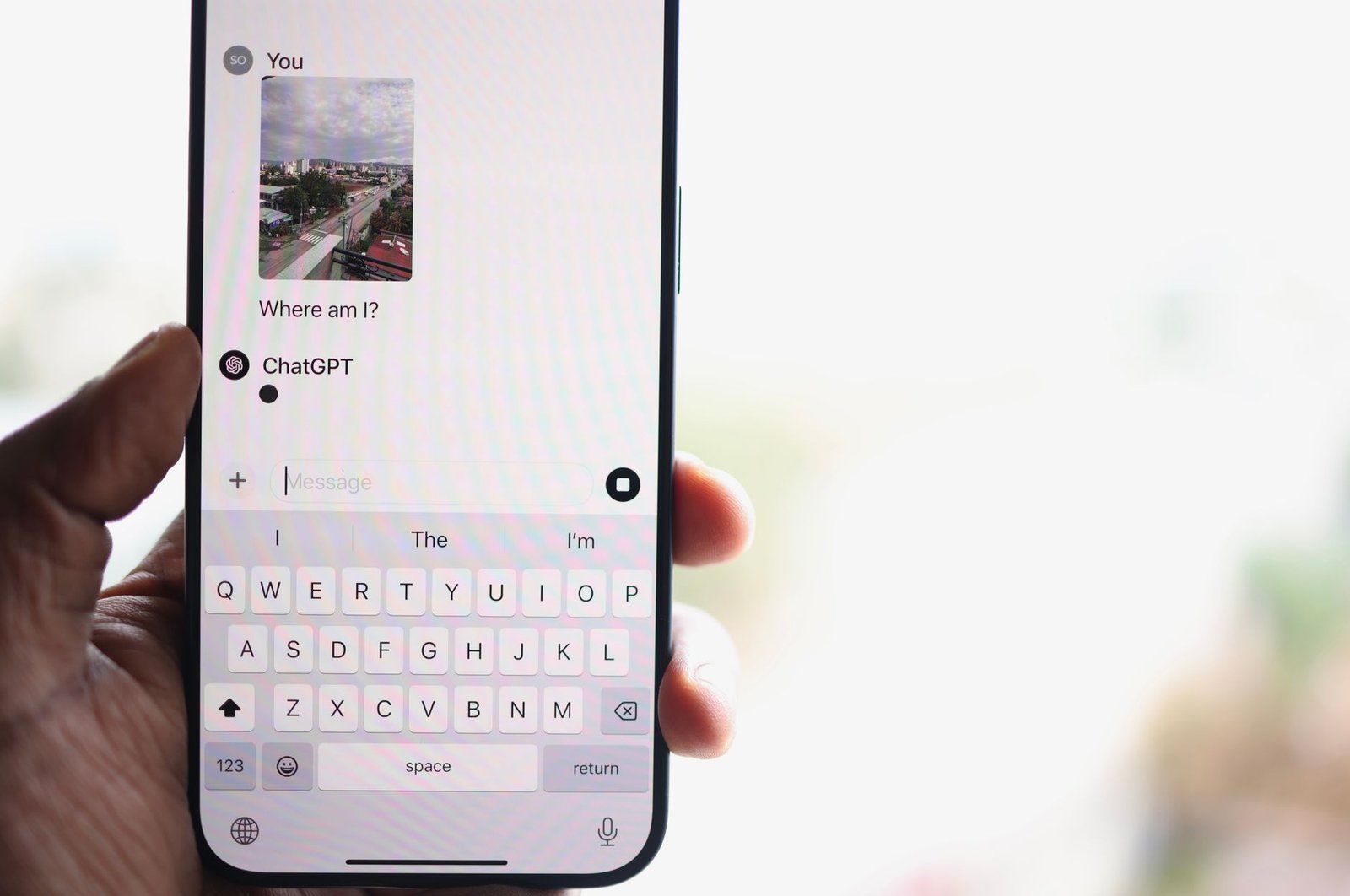 person using ChatGPT AI chat app on smartphone representing event organizer researching keynote speakers