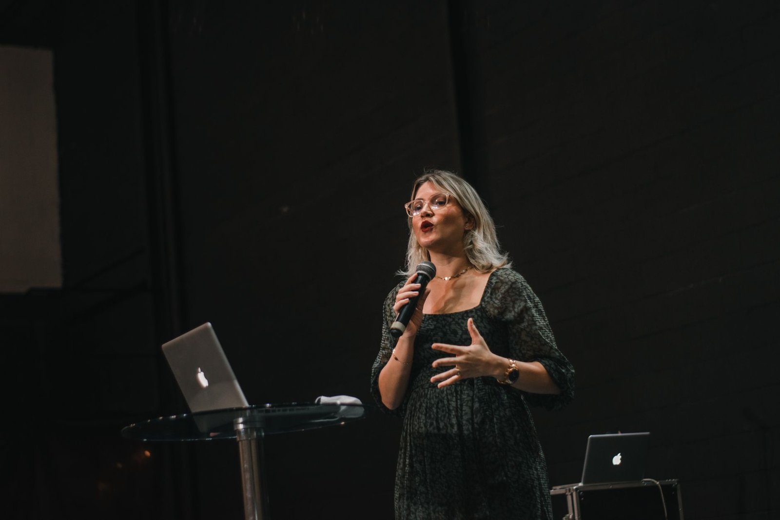 confident professional keynote speaker delivering speech on stage with microphone representing a strong speaker media kit
