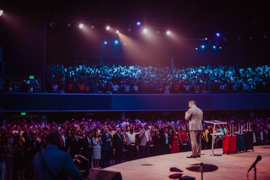 keynote speaker presenting to a large conference audience on stage