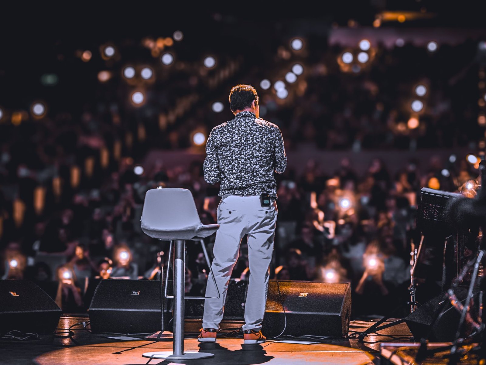 keynote speaker presenting under spotlight at a conference stage