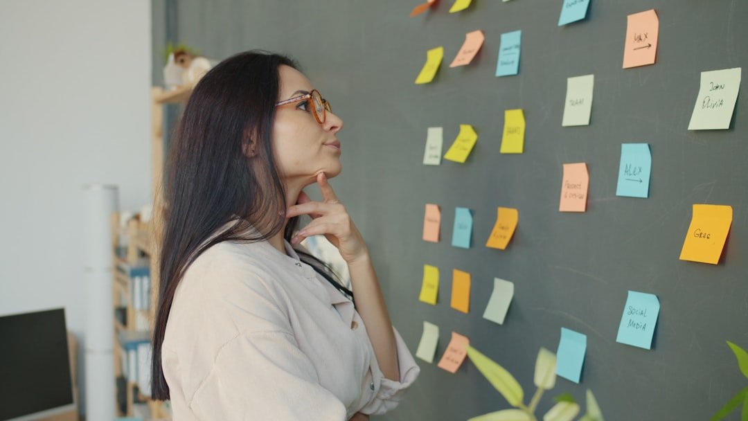 professional woman thinking and planning speaker website headline strategy with sticky notes on office wall