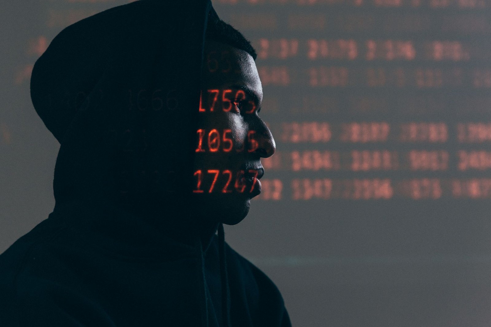 hooded figure surrounded by red code representing the automated attacks constantly scanning speaker websites for vulnerabilities