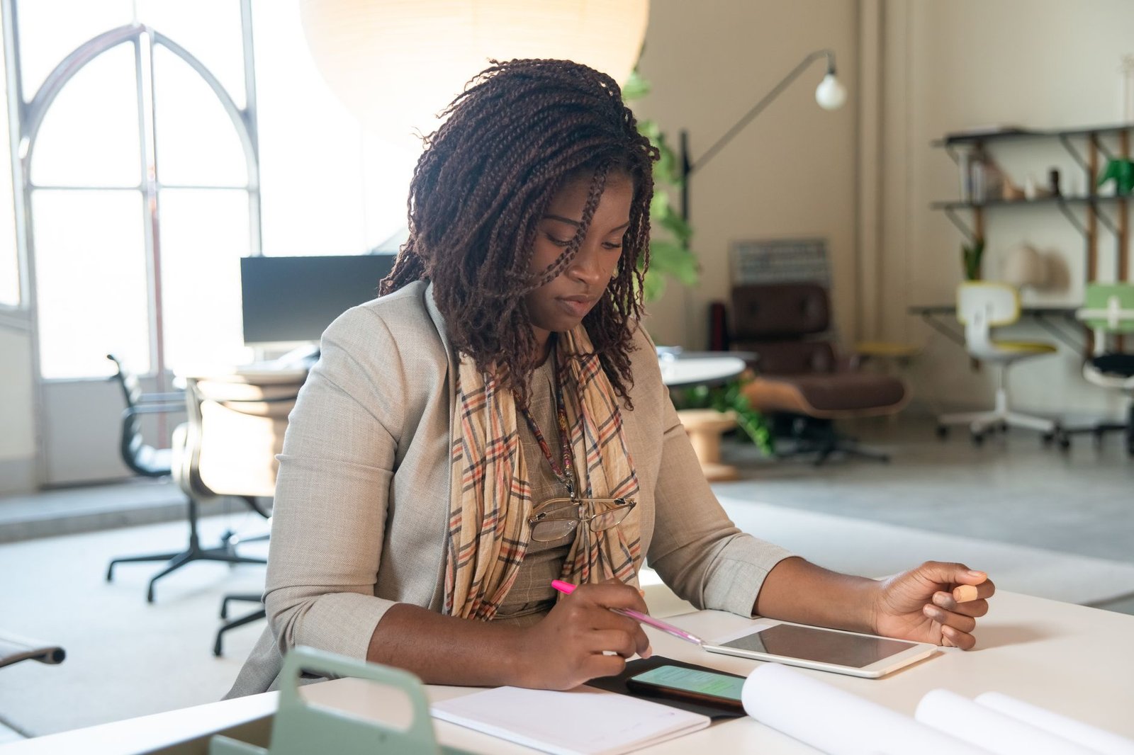 businesswoman reading content on tablet and smartphone representing an event organizer discovering a keynote speaker through their blog