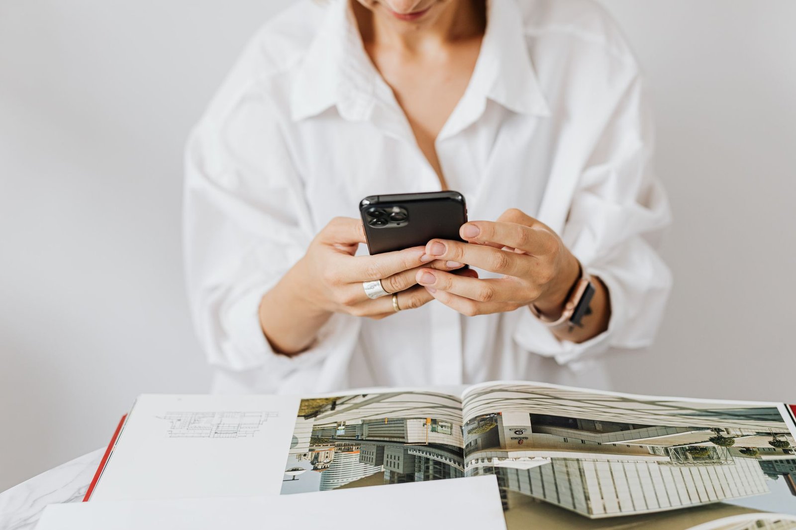 professional woman researching a keynote speaker website on her smartphone between meetings