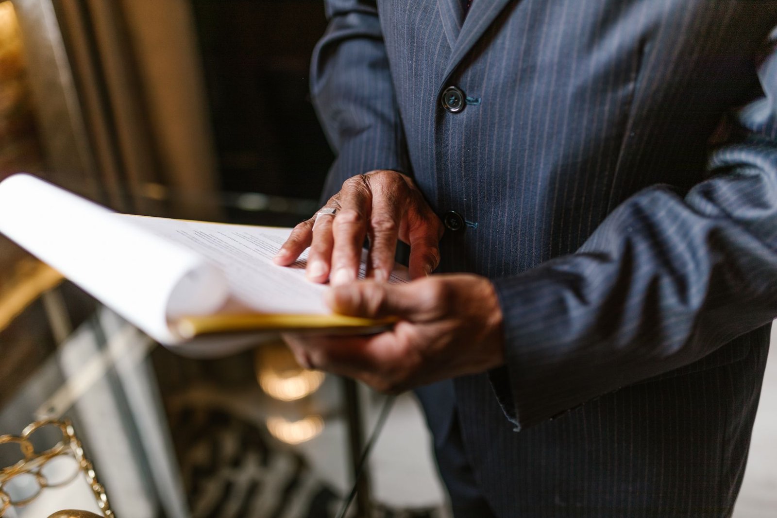 event organizer in business suit attentively reviewing keynote speaker shortlist documents making final booking decision