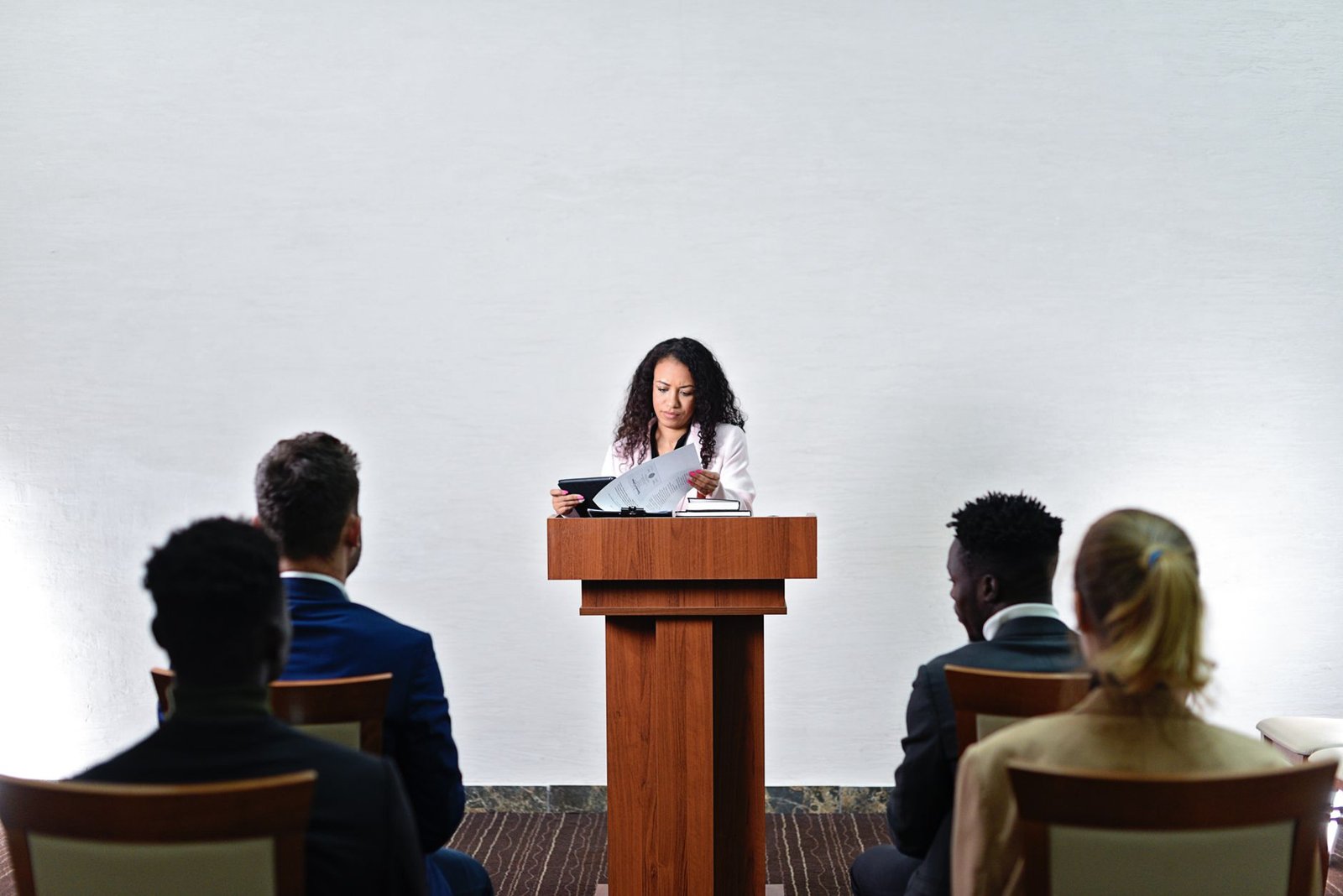confident woman delivering first keynote speech to diverse business audience in conference room