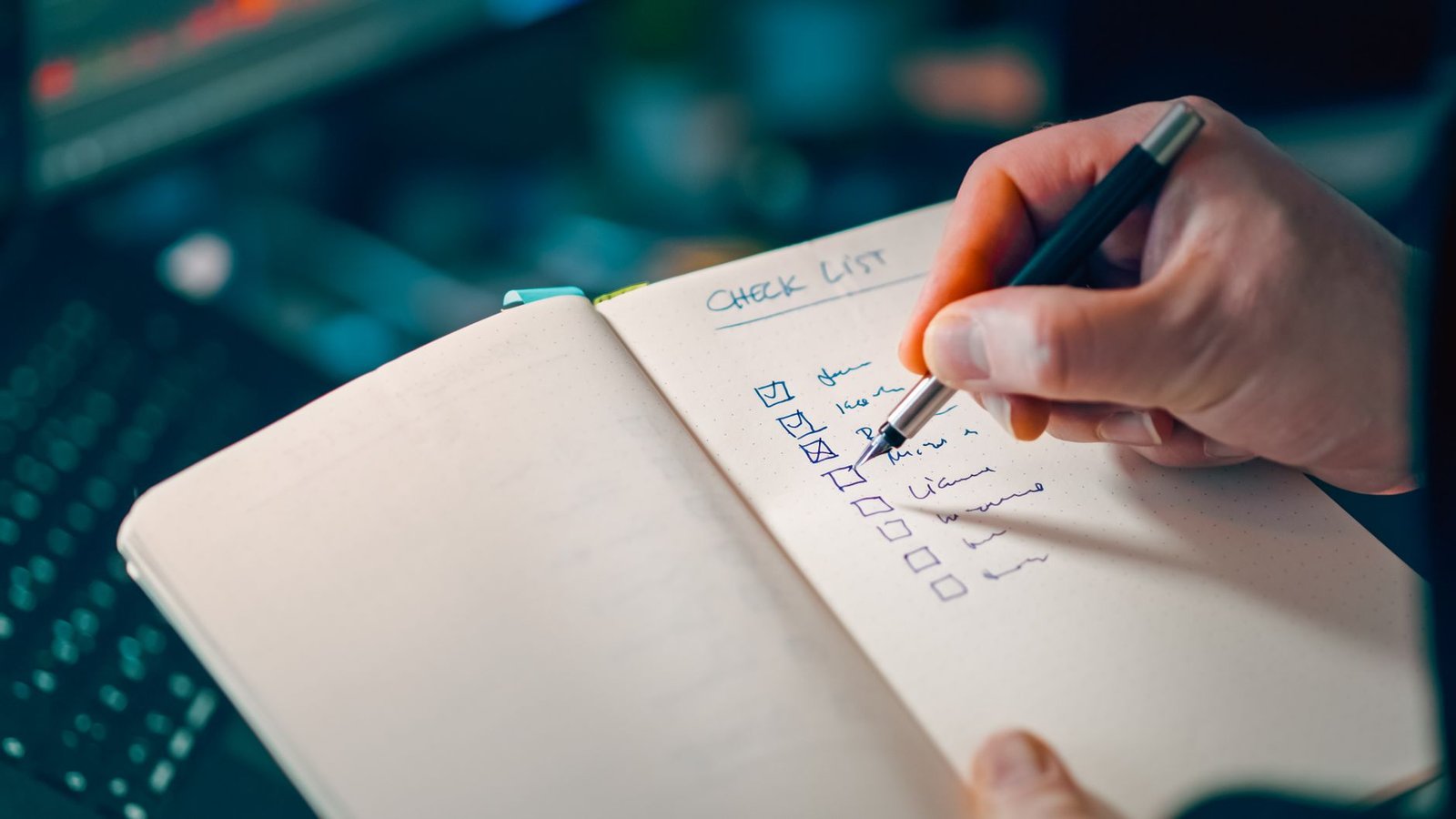hand writing a checklist representing a speaker building foundational assets before pitching for their first paid keynote gig