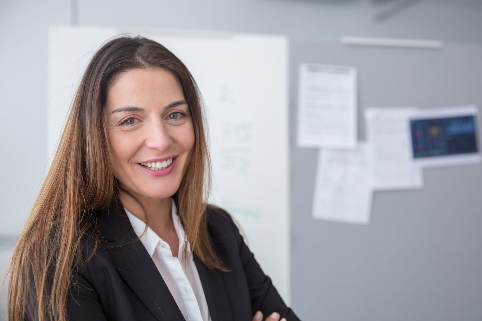 smiling businesswoman standing confidently in modern office representing the professional impression created by a well written keynote speaker bio
