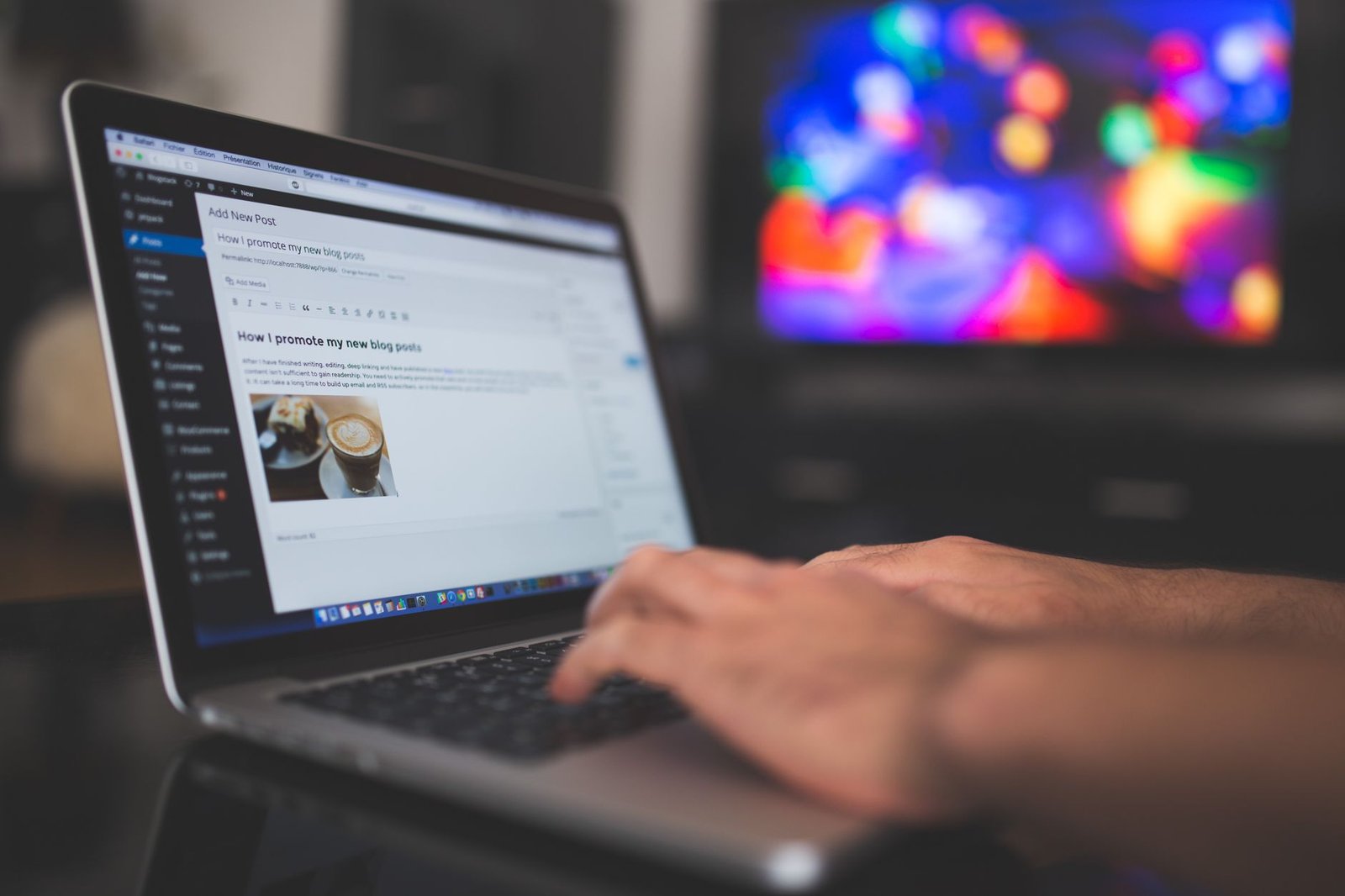 hands typing a blog post on laptop in cozy setting representing a keynote speaker writing content that books gigs