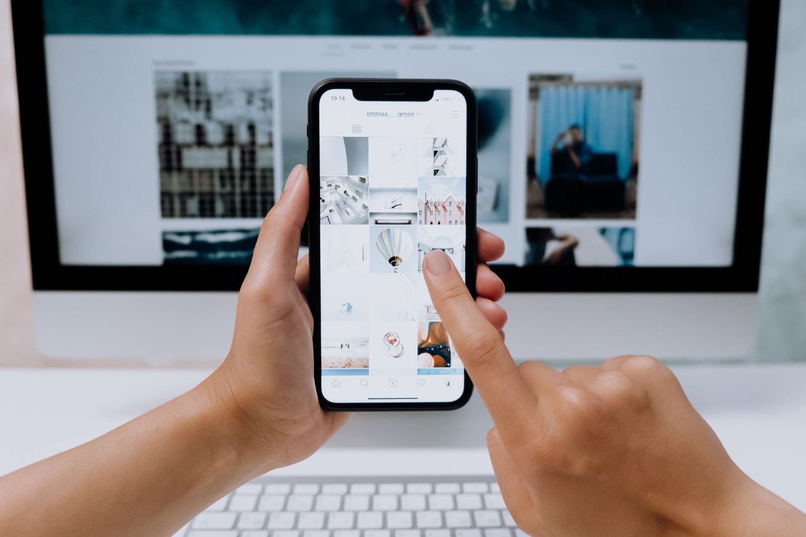 hand holding smartphone browsing a website representing an event organizer evaluating a speaker site on mobile before deciding whether to inquire