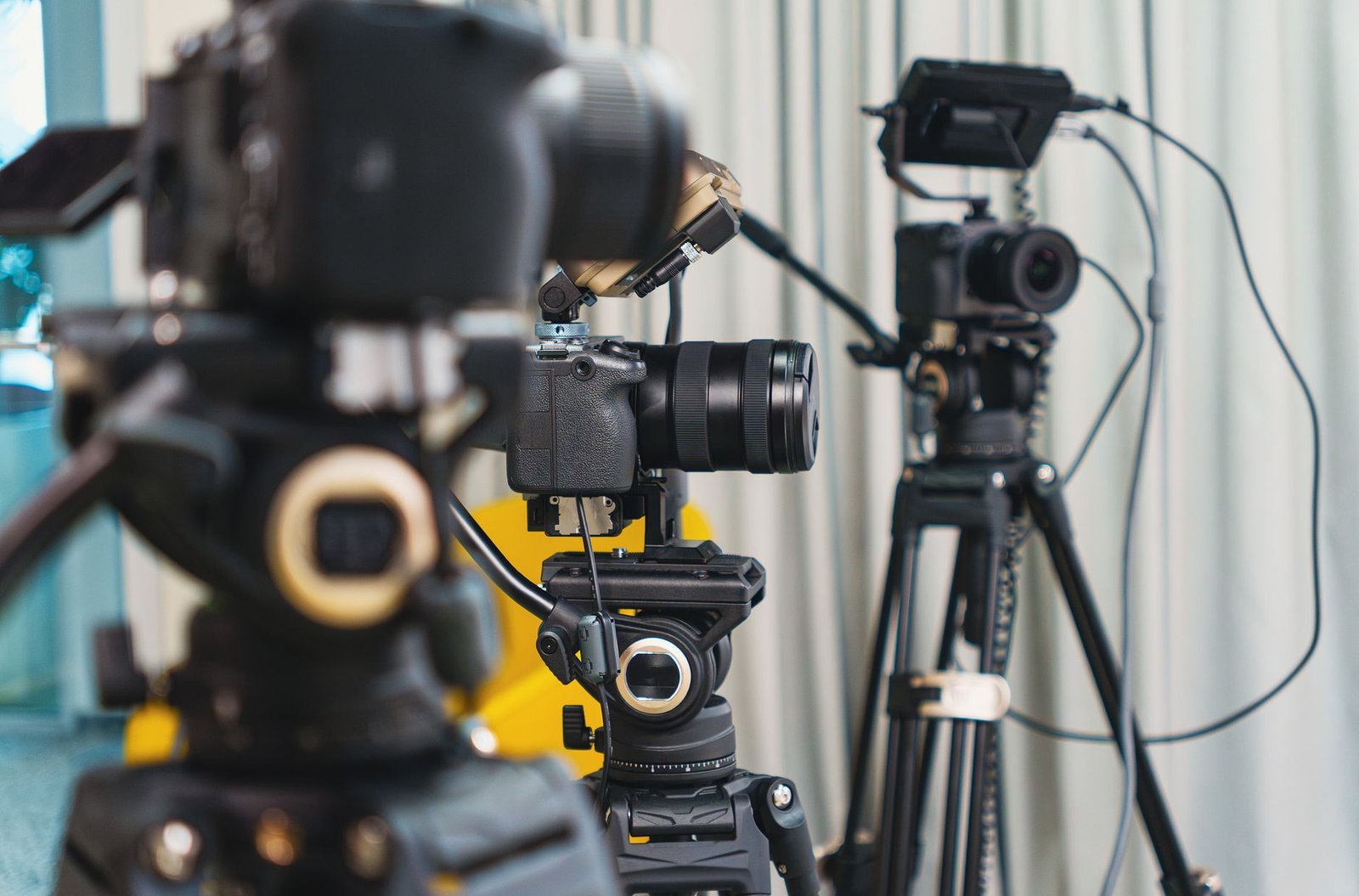 close-up of professional video cameras and tripods representing the recording quality that keeps organizers watching a speaker reel past the first seconds