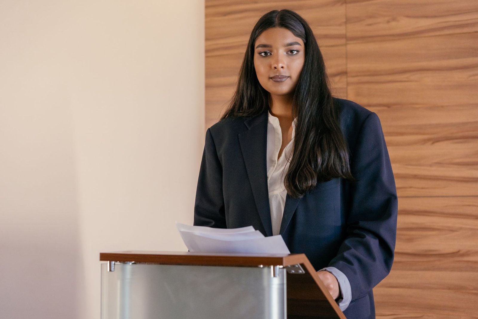 woman in a suit presenting at a podium symbolizing the leadership and business speakers StageNexa partners with long term