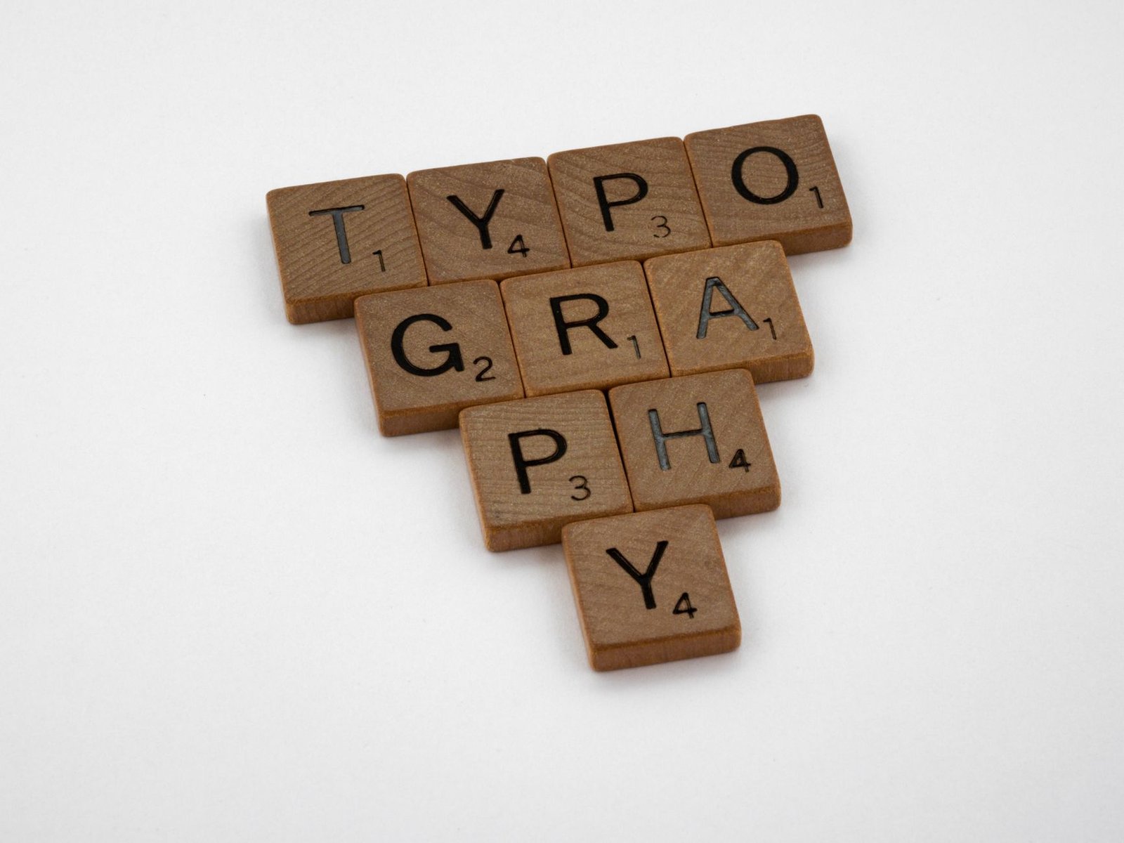 wooden letter tiles spelling typography representing deliberate font selection for a keynote speaker website