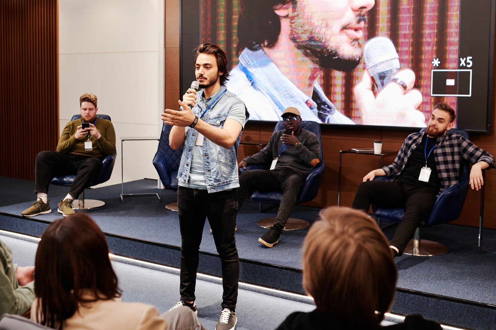 speaker holding a microphone engaging an audience at a business conference representing why keynote speakers hire StageNexa for their website