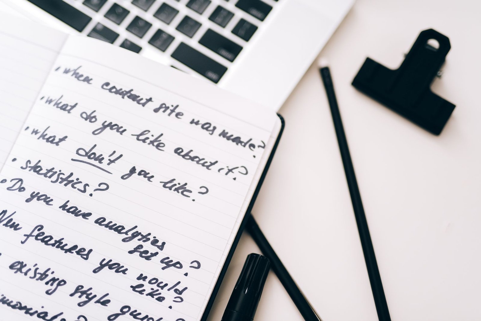 notebook with handwritten planning notes beside a laptop representing a speaker structuring their keynote topic page