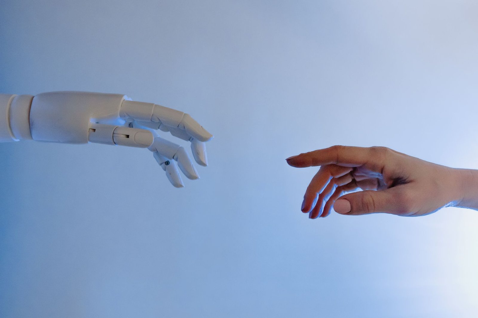a human hand reaching toward a robotic hand representing the choice between a human-built and an AI-generated keynote speaker website